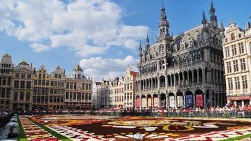 Brüsseler gotisches Rathaus am Grand Place mit einem aus Blumen ausgelegten Bild auf dem Marktplatz